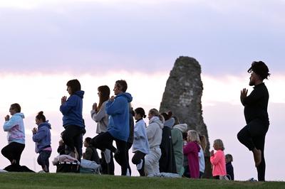 Summer Solstice Sunrise A Yoga class in the grounds of Hadleigh Castle in Essex UK greet the sunrise on the morning of t-stock-foto