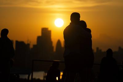 Two people hug as the watch the sunset over London on the Summer Solstice (21st June) seen from Greenwich Park, London.-stock-foto