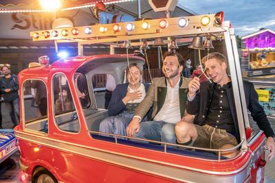 Felix Banaszak, GR?NEN-Bundesvorsitzender, im Feuerwehrauto eines Kinderkarussells, mit Katharina Schulze, Vorsitzende der Landtagsfraktion Bayern, und Dominik Krause, Zweiter B?rgermeister, Truderinger Festwoche, traditionelles bayerisches Volksfest im-stock-foto