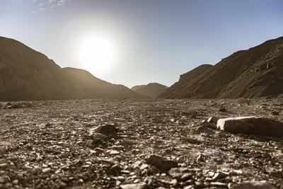Rocky valley floor stretches towards distant mountains under bright sun in marsa alam, egypt Sun shining over marsa alam-stock-foto