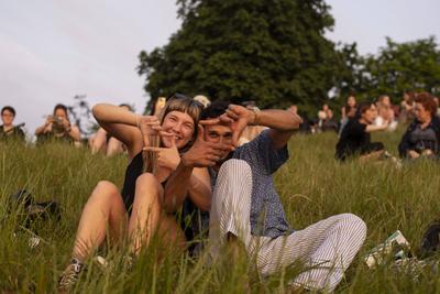 General view as people gather on the Summer Solstice (21st June) and watch a sunset over London seen from Greenwich Park-stock-foto