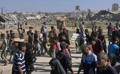 Palestinians seeking aid gather near an aid distribution site run by the U.S.-backed Gaza Humanitarian Foundation-stock-foto