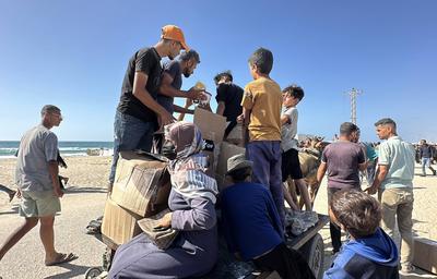 Palestinians seeking aid gather near an aid distribution site run by the U.S.-backed Gaza Humanitarian Foundation-stock-foto