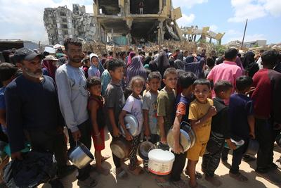Charitable organizations distribute hot meals to Palestinians in Gaza City, who are struggling with hunger-stock-foto