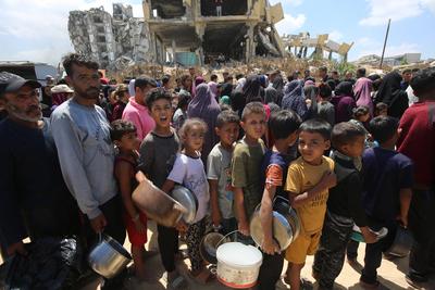 Charitable organizations distribute hot meals to Palestinians in Gaza City, who are struggling with hunger-stock-foto