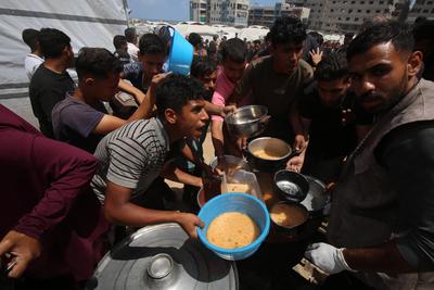 Charitable organizations distribute hot meals to Palestinians in Gaza City, who are struggling with hunger-stock-foto