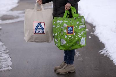 20.02.2018, Symbolfoto: ALDI S?d und ALDI Nord, Frau tr?gt Einkaufstaschen von Aldi-S?d (re) und Aldi-Nord (li) in der-stock-photo