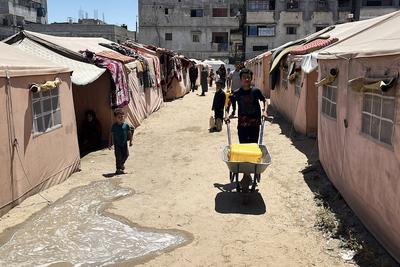 Palestinians try to meet their daily water needs by filling jerry cans with water distributed by tankers as the 'humanitarian crisis' in the region continues to deepen due to the total embargo-stock-foto