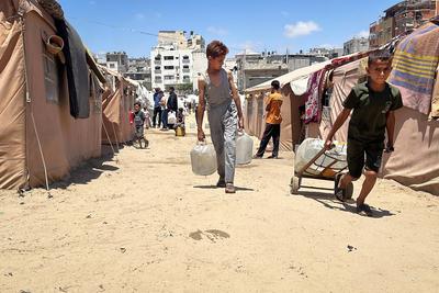 Palestinians try to meet their daily water needs by filling jerry cans with water distributed by tankers as the 'humanitarian crisis' in the region continues to deepen due to the total embargo-stock-foto