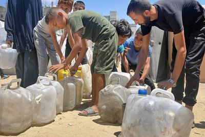 Palestinians try to meet their daily water needs by filling jerry cans with water distributed by tankers as the 'humanitarian crisis' in the region continues to deepen due to the total embargo-stock-foto