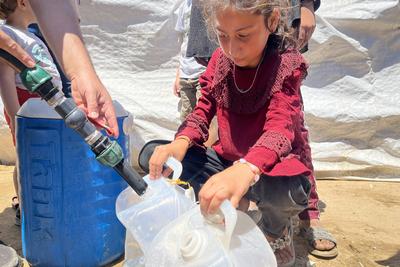 Palestinians try to meet their daily water needs by filling jerry cans with water distributed by tankers as the 'humanitarian crisis' in the region continues to deepen due to the total embargo-stock-foto