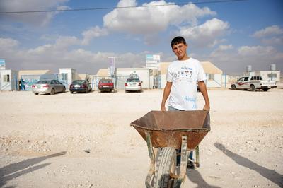 Child Labor in Refugee Camp Teen Boy Working & Child Labor in Refugee Camp Al Zaatari, Jordan, after having fled, the Sy-stock-photo