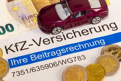 Symbolbild KfZ-Versicherung: Nahaufnahme von Vertragsunterlagen und einem Modellauto *** Symbolic image of car insurance-stock-foto