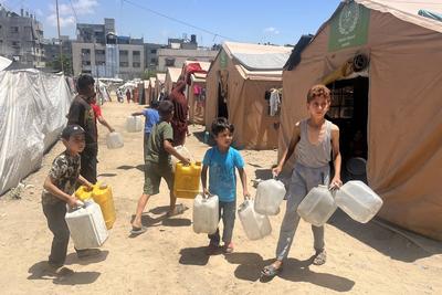 Palestinians try to meet their daily water needs by filling jerry cans with water distributed by tankers as the 'humanitarian crisis' in the region continues to deepen due to the total embargo-stock-foto