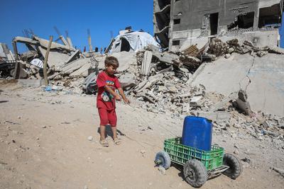 Palestinians carry jerry cans filled with water distributed by a water tanker, in Gaza-stock-foto