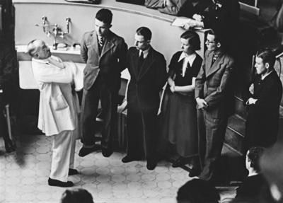 Professor Ferdinand Sauerbruch unterh?lt sich mit Medizinstudenten im H?rsaal der Charite in Berlin, Deutschland ca. 193-stock-foto