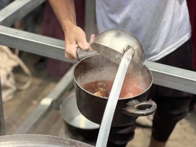 Internally displaced Palestinians gather in a charity kitchen to receive limited rations amid a shortage of food-stock-foto