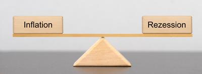 Auf einer Wippe liegen zwei Holzkl?tze, beschriftet mit Inflation und Rezession *** at a Seesaw are Two Wooden blocks, l-stock-foto