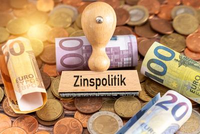 Bavaria, Germany - May 31, 2025: PHOTOMONTAGE, A stamp with the term interest rate policy is on euro banknotes - symboli-stock-foto
