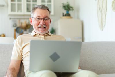 Zuversichtlich, stilvoll gl?cklich mittleren Alters Senior Mann mit Laptop zu Hause. Stilvolle ?ltere reifen 60er Jahre Bart Gro?vater sitzt auf der Couch Blick auf Computer-Bildschirm Tippen Chatten Lesen Schreiben von E-Mail.-stock-photo