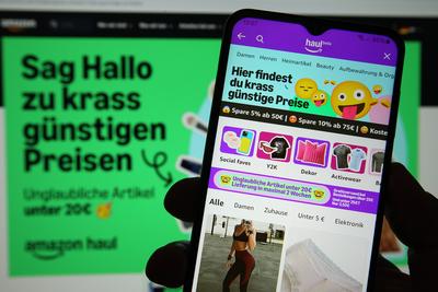 Auf einem Laptop wurde die Website von Amazon ge?ffnet. Davor wurde auf einem Smartphone die App von Amazon mit der Beta-stock-foto