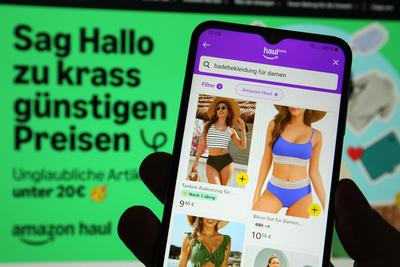 Auf einem Laptop wurde die Website von Amazon ge?ffnet. Davor wurde auf einem Smartphone die App von Amazon mit der Beta-stock-foto