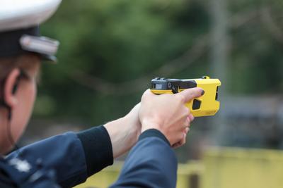 Themenbild Polizei mit Tasern Eine Polizistin zielt mit einem neuen Taser. Die Polizei NRW ist mit Tasern ausgestattet w-stock-foto