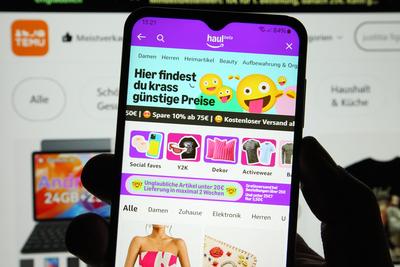 Auf einem Laptop wurde die Website vom chinesischen Online-Martplatz TEMU ge?ffnet. Davor wurde auf einem Smartphone die-stock-foto