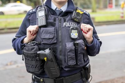 Polizei, Polizistin mit Ausr?stungsweste, CO Messger?t, oben eine Bodycam, Erste-Hilfe Pack, Taser, digitales Funkger?t,-stock-foto