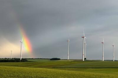 Zwischen mehreren Windraedern entsteht am Abendhimmel auf der Schwaebischen Alb ein regenbogen-stock-photo