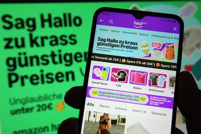 Auf einem Laptop wurde die Website von Amazon ge?ffnet. Davor wurde auf einem Smartphone die App von Amazon mit der Beta-stock-foto