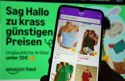 Auf einem Laptop wurde die Website von Amazon ge?ffnet. Davor wurde auf einem Smartphone die App von Amazon mit der Beta-stock-foto