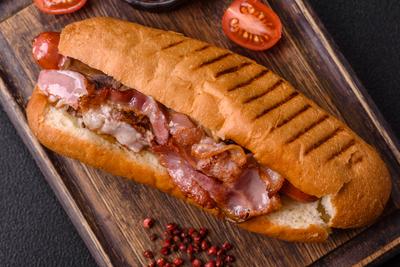 Leckerer saftiger Hot Dog mit Wurst, Speck, So?e, Salz und Gew?rzen-stock-foto