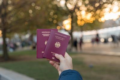 9 December 2022: A man holds two German passports in his hand. Passport *** Ein Mann h?lt zwei deutsche Reisep?sse in de-stock-photo