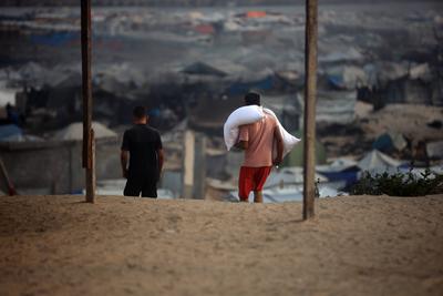 People carry their sacks of flour Flour they got from aid trucks in Gaza City, where there is a food crisis due to Israeli attacks-stock-foto