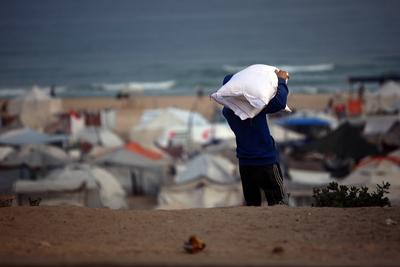 People carry their sacks of flour Flour they got from aid trucks in Gaza City, where there is a food crisis due to Israeli attacks-stock-foto