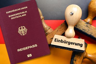 FOTOMONTAGE, Stempel mit Aufschrift Einb?rgerung auf deutscher Fahne und deutscher Pass, Gesetz zur Modernisierung des S-stock-photo
