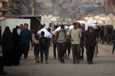 People carry their sacks of flour Flour they got from aid trucks in Gaza City, where there is a food crisis due to Israeli attacks-stock-foto
