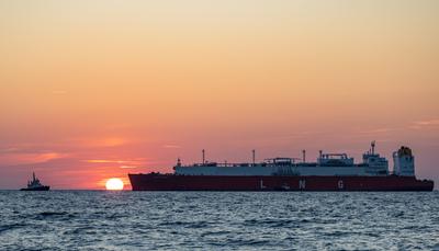 Tanker bringt LNG nach Ruegen Bei Sonnenaufgang bugsieren Schlepper den LNG-Tanker HELLAS DIANA in den Hafen Mukran auf-stock-foto