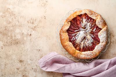 Hausgemachte Rhabarber Galette mit Stern-Muster auf alten Beton Tisch Hintergrund gemacht. Prozess des Backens. Offener Kuchen. Weihnachts- und Neujahrsbackwaren. Draufsicht auf selbstgemachte Kuchenkruste auf dem Tisch.-stock-photo