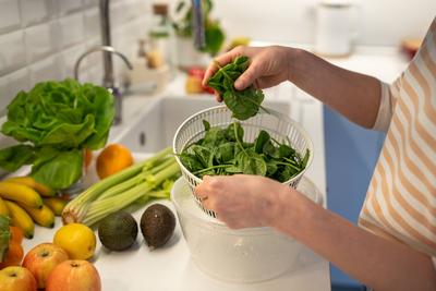 Cropped Bild der weiblichen H?nde Kochen frischen Salat von gr?nem Spinat. N?tzliche Lebensmittel f?r eine gute Gesundheit.-stock-photo
