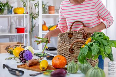 Young woman placing vegetables on the worktop. Back from the organic store. 016643_078-stock-photo
