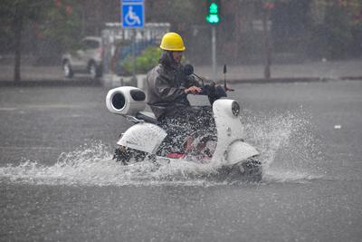 DONGFANG, CHINA - JUNE 14: A local resident rides through flooded street following the impact of Typhoon Wutip on June 1-stock-photo