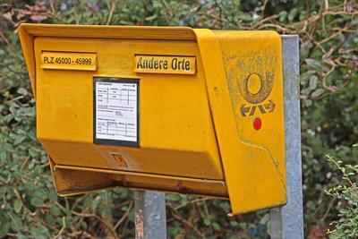 Postk?sten in der Stadt und auf dem Land Ein gelber Briefkasten der Deutschen Post steht am Rand einer Stra?e *** Postbo-stock-foto