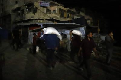 People carry their sacks of flour Flour they got from aid trucks in North Gaza Strip, where there is a food crisis due to Israeli attacks-stock-foto