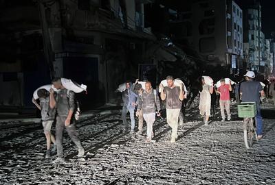 People carry their sacks of flour Flour they got from aid trucks in North Gaza Strip, where there is a food crisis due to Israeli attacks-stock-foto