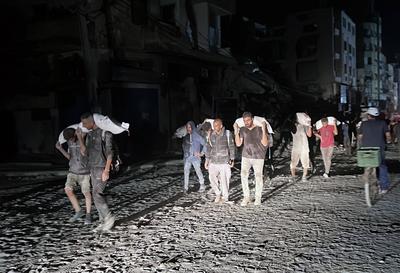 People carry their sacks of flour Flour they got from aid trucks in North Gaza Strip, where there is a food crisis due to Israeli attacks-stock-foto