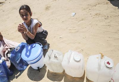 Palestinians carry jerry cans filled with water distributed by a water tanker-stock-foto