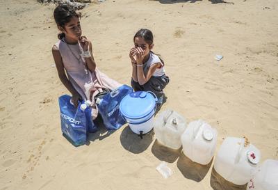 Palestinians carry jerry cans filled with water distributed by a water tanker-stock-foto