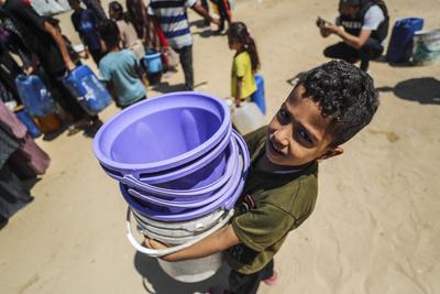Palestinians carry jerry cans filled with water distributed by a water tanker-stock-foto